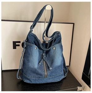 Detailansicht der dunkelblauen Denim-Tasche mit Metallreißverschlüssen und Gurten