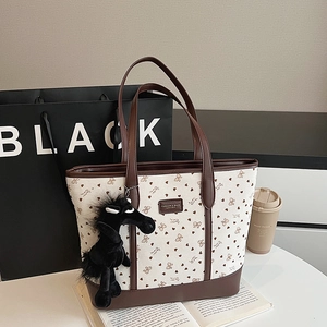 Τσάντα tote από καμβά με σχέδια καρδιάς και καφέ δερμάτινες λαβές σε λευκό τραπέζι