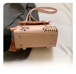 Detailed bottom view of pink crossbody bag showing silver metal protective feet studs