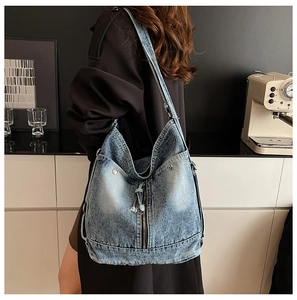 Détail du sac cabas en denim vintage avec texture délavée et rivets métalliques