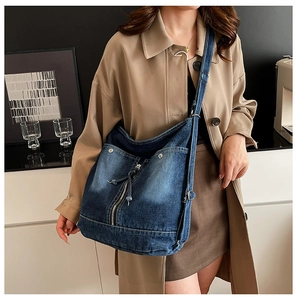 Detailansicht der gewaschenen blauen Denim-Tasche mit Metallreißverschluss und Riemen