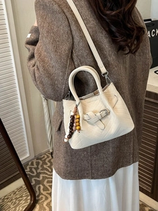 Borsa a secchiello beige con trama trapuntata a V e ciondolo con perline in legno