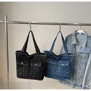 Detail of vintage denim tote bags with front pockets and long shoulder straps