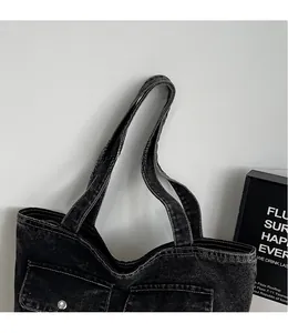 Detail of vintage grey denim tote bag showing smooth straps and white contrast stitching