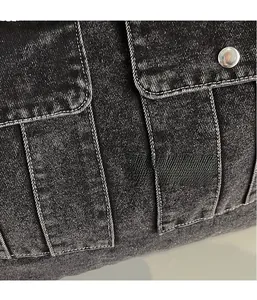 Macro shot of charcoal denim fabric texture with pockets and metallic silver buttons