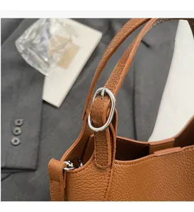 Close-up of brown textured leather bucket bag with premium silver buckle detail