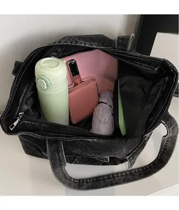 Interior view showing large capacity of washed black denim tote bag with daily essentials
