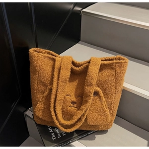 Close-up of brown plush tote bag featuring a cute 3D bear face and soft teddy fleece texture