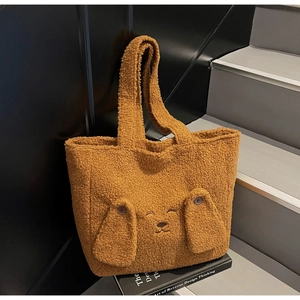 Close-up of plush brown dog tote bag with long ears on a book over modern stairs