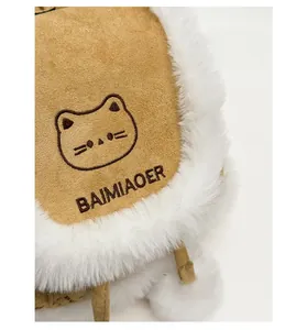 Close-up of cat embroidery and white faux fur trim on a brown plush backpack