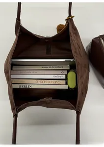 Internal view of a large brown suede tote bag showing laptop, books, and umbrella capacity
