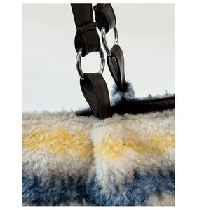 Detail of soft striped faux fur tote bag showing silver metal ring hardware and brown handle