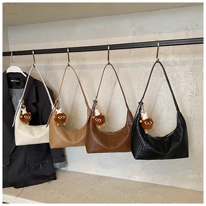 Detail of woven crescent shoulder bags in four colors with cute plush eyewear pendants