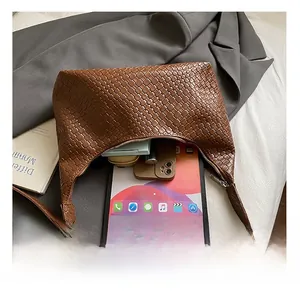 Internal capacity of brown woven tote bag holding a tablet, phone, and cosmetics