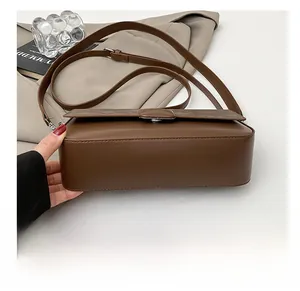 Detailed view of the flat bottom and smooth leather texture of a brown crossbody bag