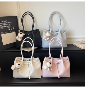 Quatre sacs cabas en noir, bleu, beige et rose avec des breloques chiens en peluche