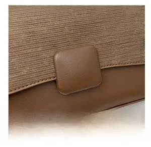 Detail showing brown corduroy and smooth leather textures with a square decorative buckle