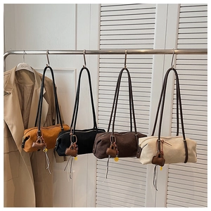 Collection of four large suede-style cylinder shoulder bags in earth-tone colors