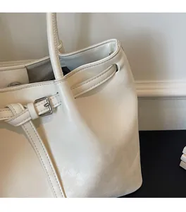 Détail du sac cabas blanc crème montrant la boucle argentée et la texture du cuir souple