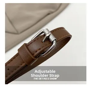 Detail of adjustable dark brown leather shoulder strap with polished silver metal buckle