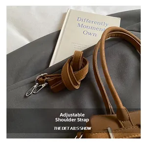 Close-up of adjustable brown leather shoulder strap with silver lobster clasps