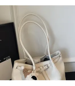 Détail du cabas blanc cassé avec doubles bretelles et un joli charm en forme d'ours