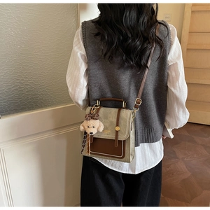 Modelweergave van vintage crossbodytas met pluche teddybeerbedeltje en verstelbare riem