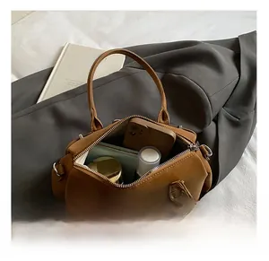Internal view of the brown retro handbag showing capacity for phone and cosmetics