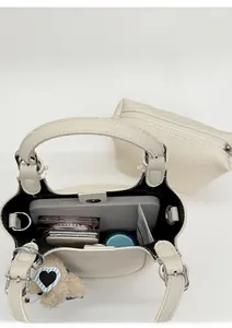 Detail of beige bucket bag showing interior capacity with phone and cosmetics
