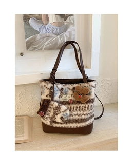 Close-up of wool tote bag with vintage color blocks and brown teddy bear charm detail