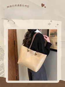 Detail of a cream faux leather tote bag with dark brown straps shown in a retro lifestyle setting