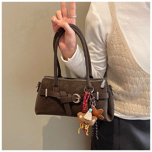 Detail of vintage matte brown Boston bag with plush bear charm and metallic buckle
