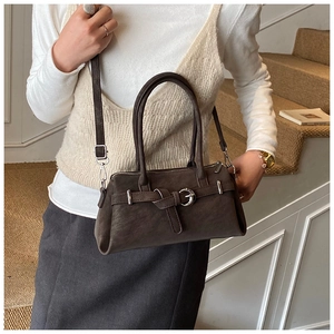Close-up of retro brown matte leather texture and silver buckle detail on handbag