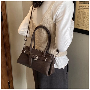 Detail of vintage dark brown faux leather pillow bag with adjustable strap and buckle