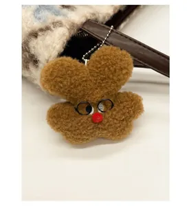Close-up of brown plush animal pendant with glasses and lamb wool texture