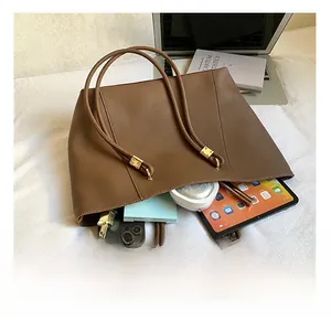 Brown leather tote bag interior showing large capacity for laptop and daily essentials