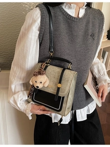 Retro crossbody tas met kleurvlakken en pluche puppy hanger gedragen door model
