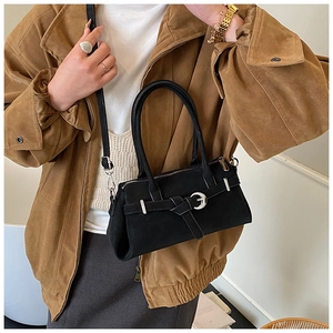 Minimalist black suede baguette bag with silver buckle and detachable shoulder strap detail