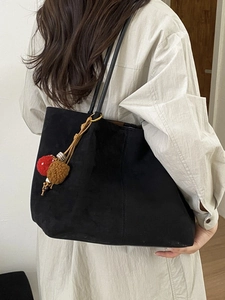 Grand sac cabas noir avec breloque champignon porté à l'épaule pour le style quotidien
