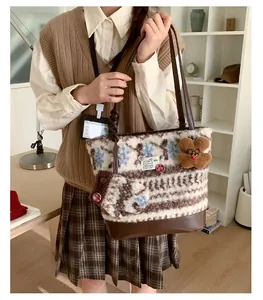 Detail of snowflake jacquard knit tote bag with brown leather base and mini pouch