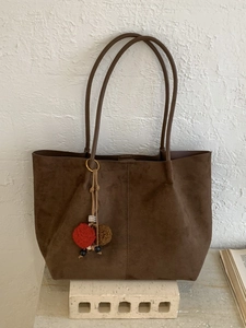 Grand sac cabas marron foncé minimaliste avec charm décoratif sur support artistique