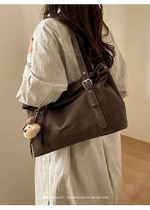 Détail du grand sac cabas rétro marron avec charme d'ours en peluche et étiquette mode