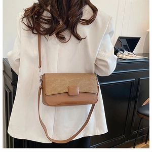 Detail of minimalist leather crossbody bag styled with a white blazer for casual commute