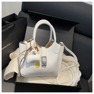 Detalle de bolso cubo de cuero blanco con cierre de reloj único en caja de regalo