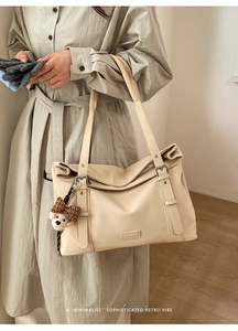 Détail du sac cabas crème avec boucle décorative et pendentif ourson mignon en peluche