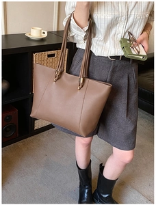 Detail of a dark brown large tote bag in matte PU leather with slim shoulder straps