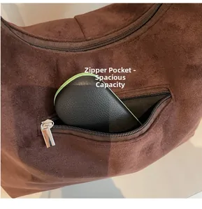 Detailed view of the dark brown suede crossbody bag's front zipper pocket and texture