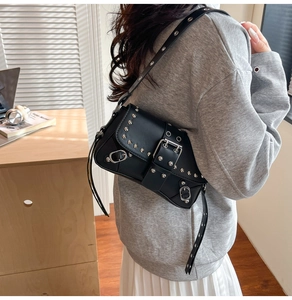 Detailed side view of Y2K style black faux leather shoulder bag with silver studs and buckles