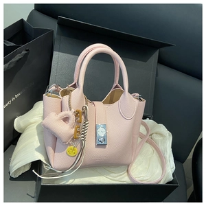 Bolso tipo cubo de cuero rosa con cierre de dial y colgantes en caja de regalo negra