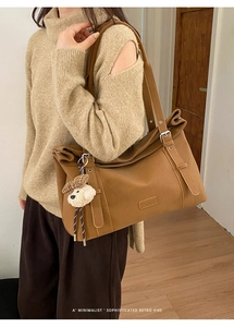Détail du sac fourre-tout caramel avec pendentif chien à carreaux et boucle rétro
